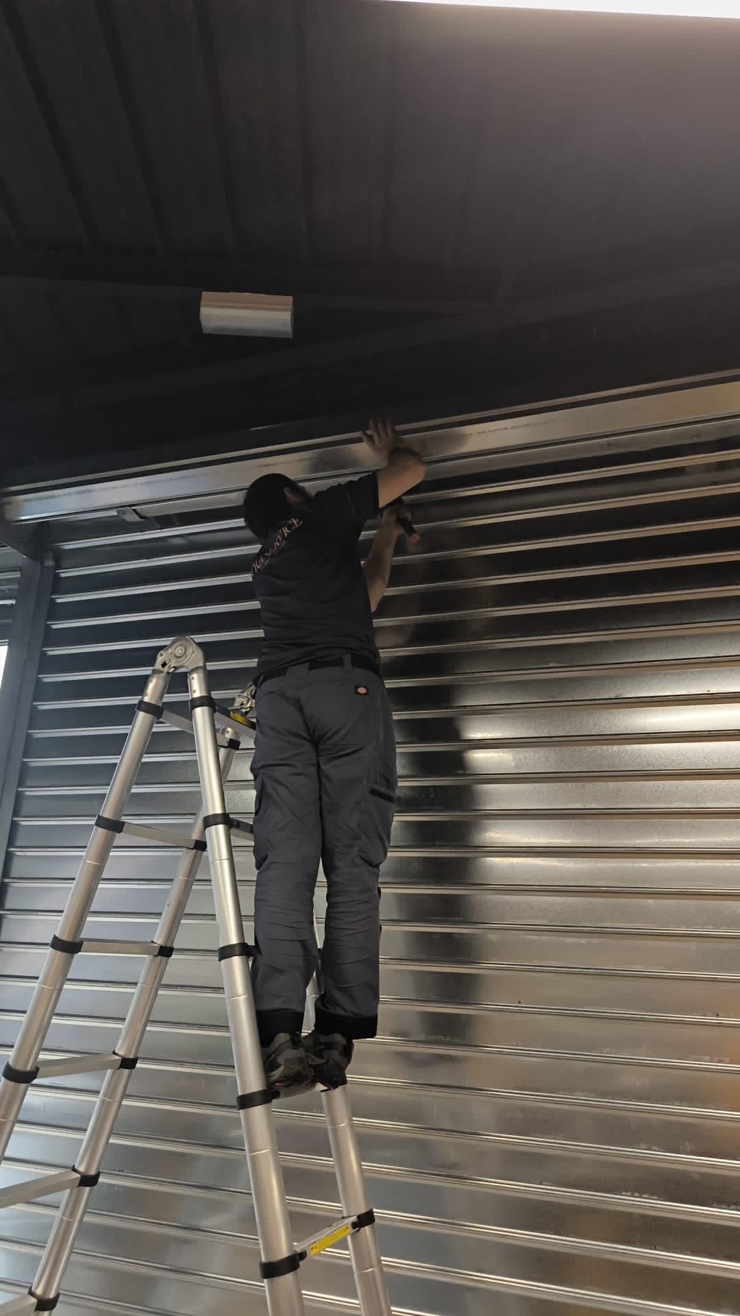 Technicien Straservice en intervention sur un rideau métallique
